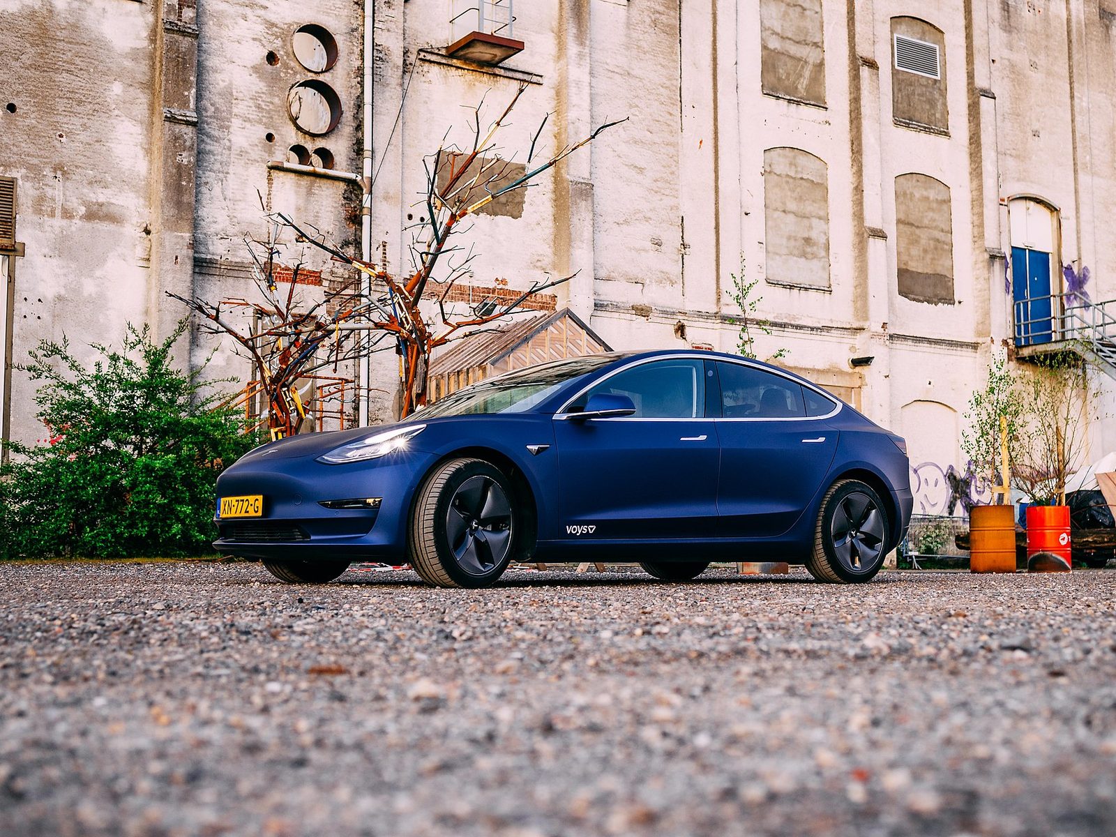 Blue wrapped Tesla Model 3 with company branding